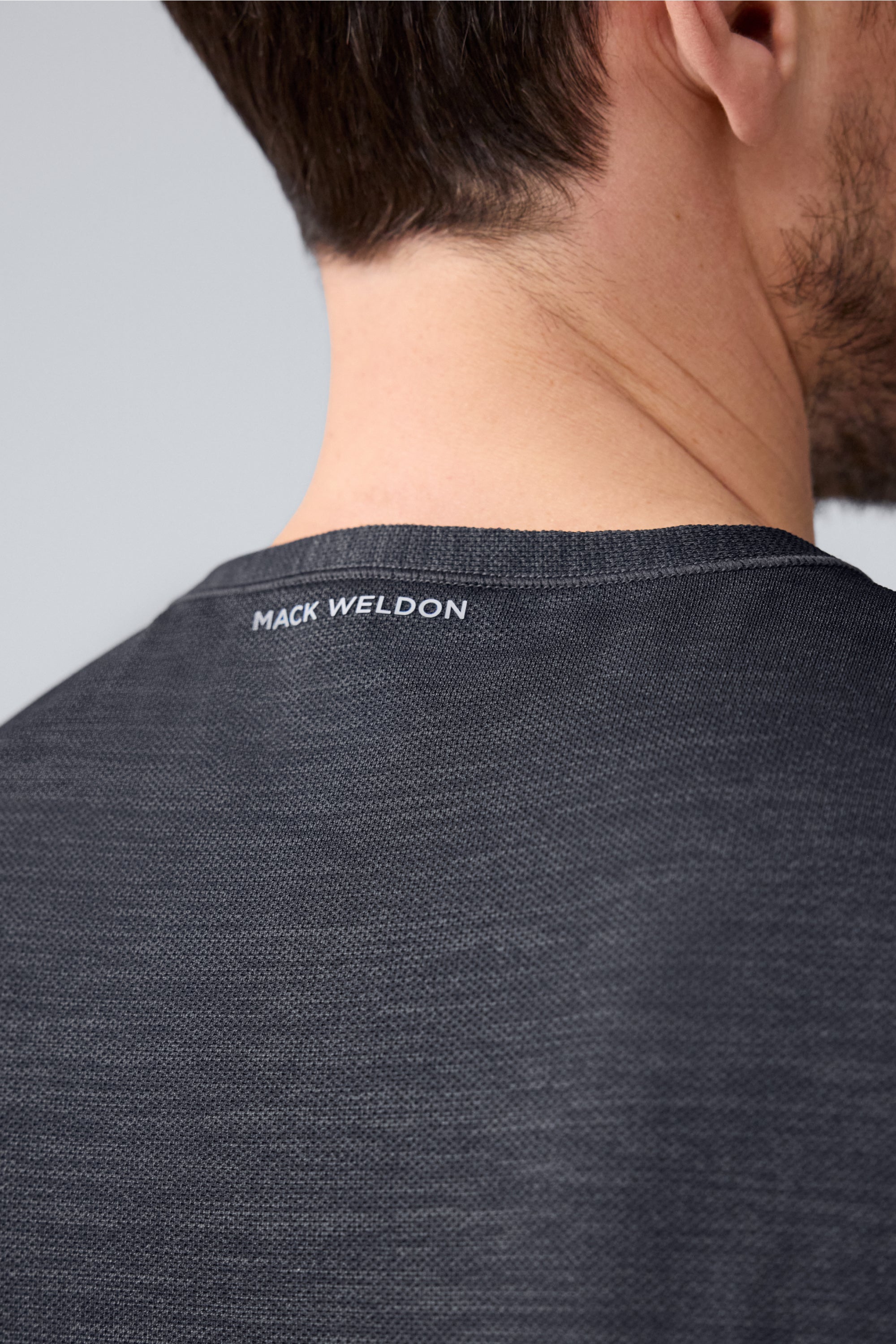 Detailed back view of a man wearing AIRKNITx Crew Neck T-Shirt in Anthracite